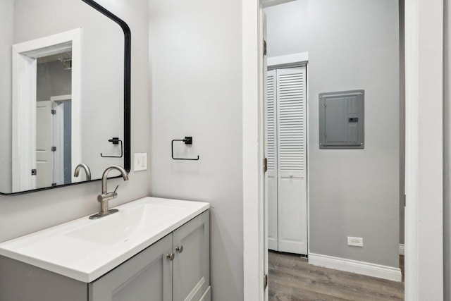 bathroom featuring hardwood / wood-style flooring, vanity, and electric panel