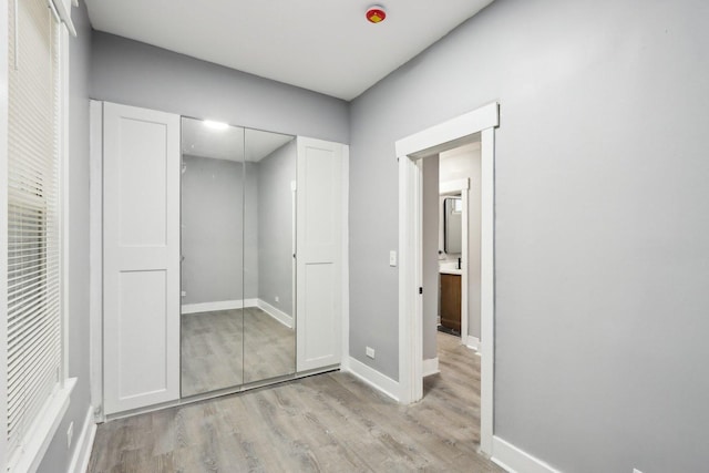 unfurnished bedroom featuring light hardwood / wood-style flooring and a closet