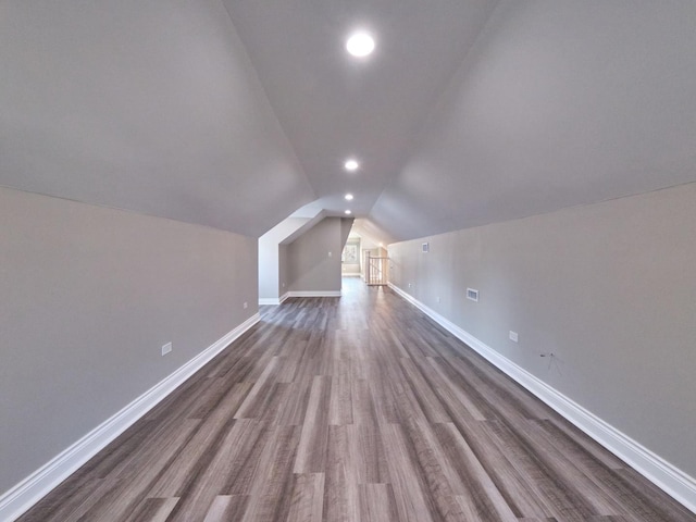 bonus room with hardwood / wood-style flooring and vaulted ceiling