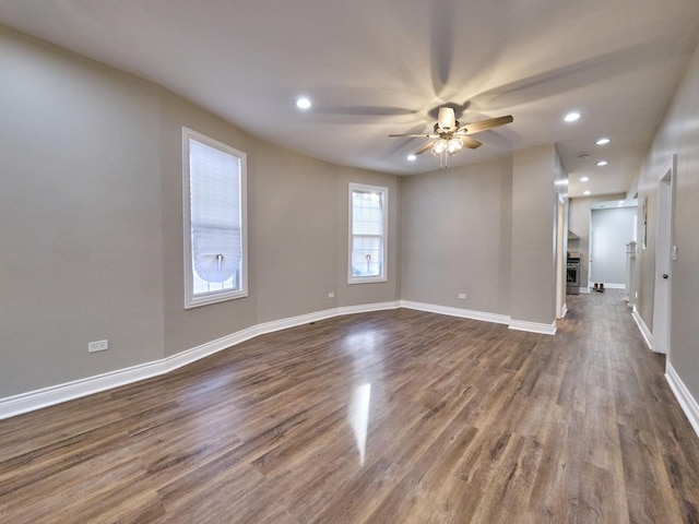 unfurnished room with ceiling fan and dark wood-type flooring