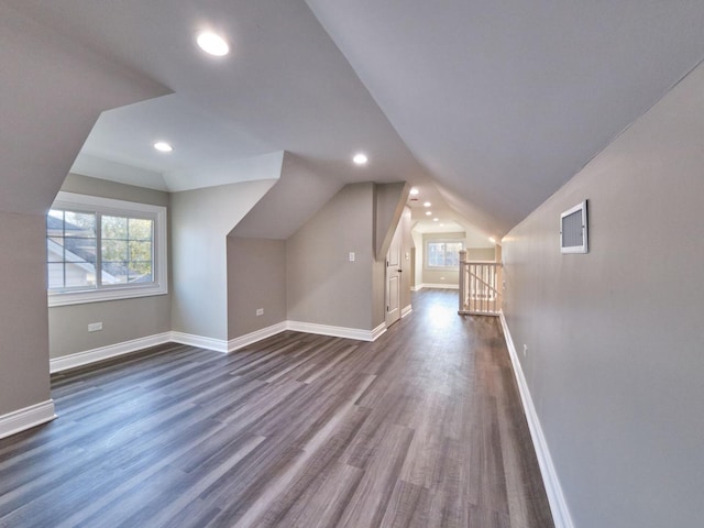 bonus room with dark wood-type flooring and vaulted ceiling