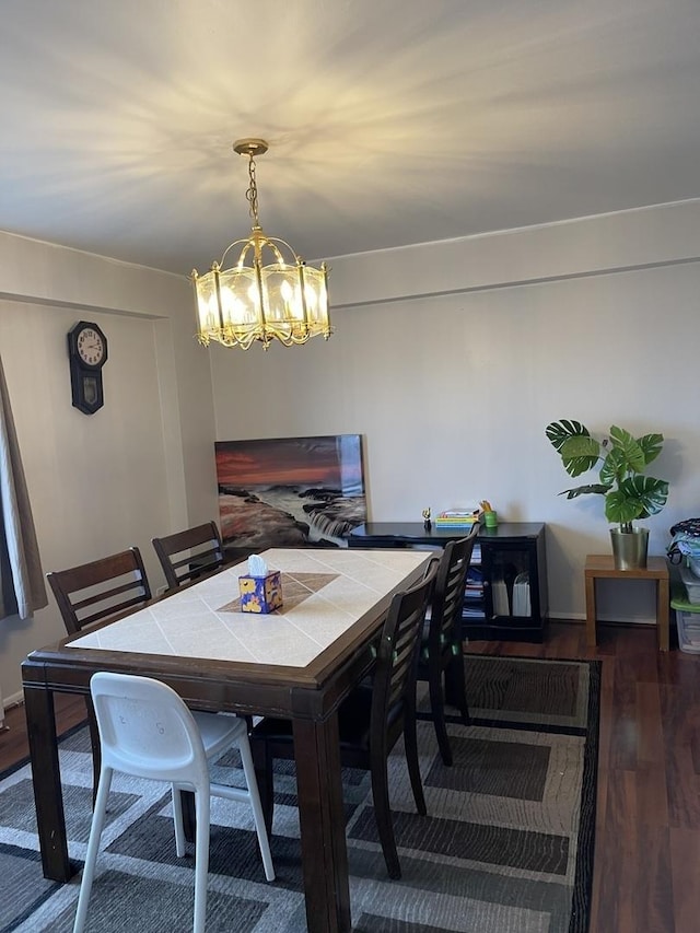 dining room with dark wood-type flooring and an inviting chandelier