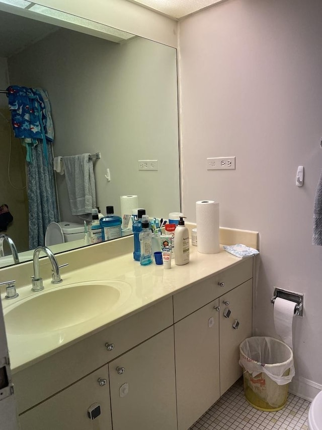 bathroom featuring tile patterned floors, vanity, and toilet