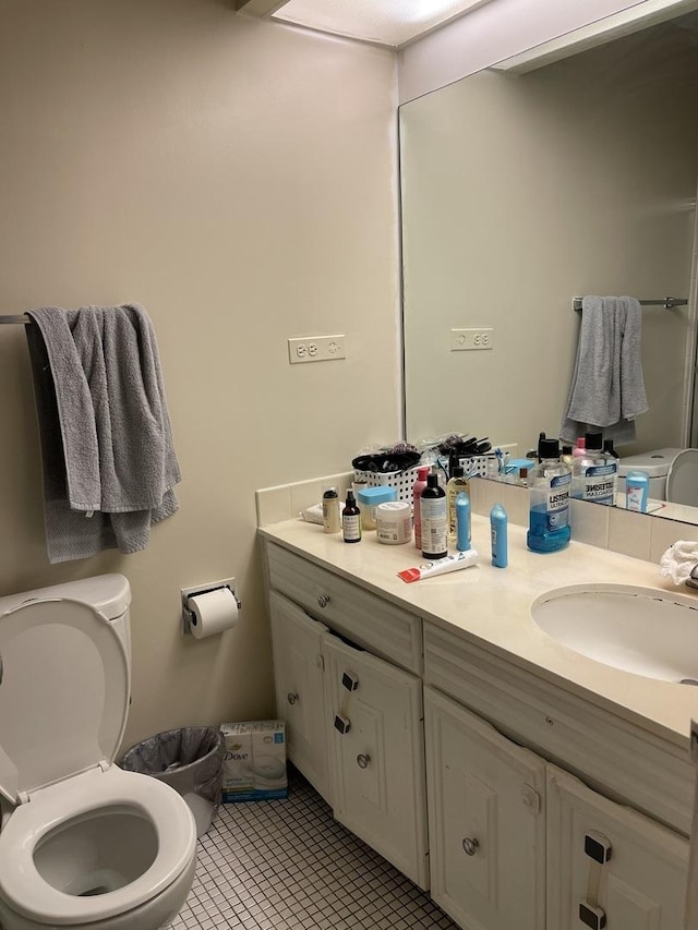 bathroom featuring tile patterned flooring, vanity, and toilet