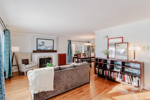 living room featuring ornamental molding and light hardwood / wood-style flooring