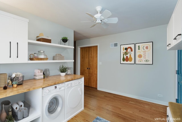 laundry room featuring ceiling fan, cabinets, separate washer and dryer, and light hardwood / wood-style floors