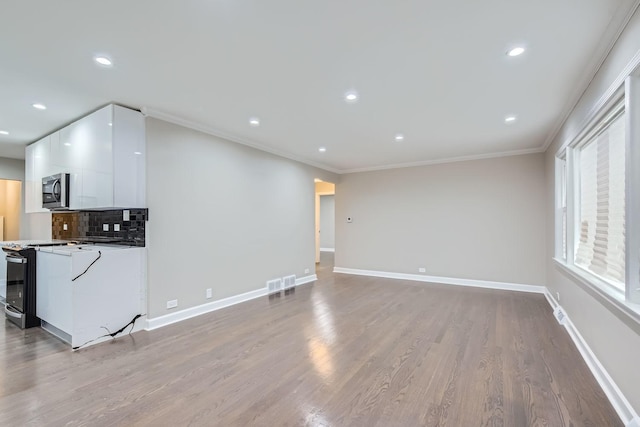 unfurnished living room with light wood-type flooring and ornamental molding