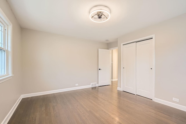 unfurnished bedroom featuring hardwood / wood-style flooring and a closet