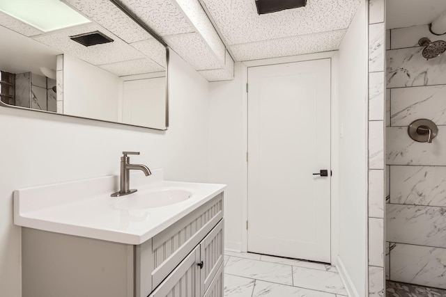 bathroom featuring a tile shower and vanity