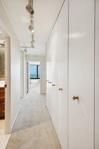 hallway with crown molding and light colored carpet