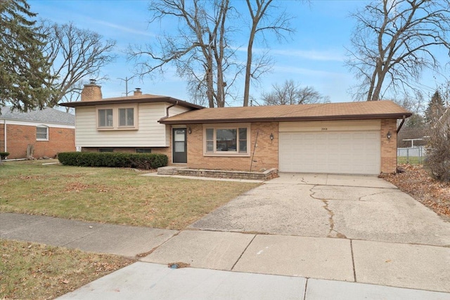 tri-level home featuring a front lawn and a garage