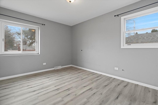 unfurnished room featuring plenty of natural light and light hardwood / wood-style floors