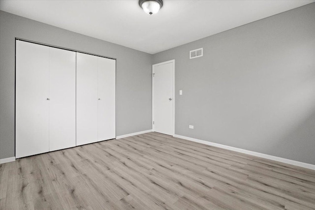 unfurnished bedroom featuring a closet and light hardwood / wood-style flooring