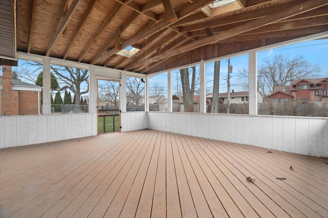 unfurnished sunroom with vaulted ceiling with skylight