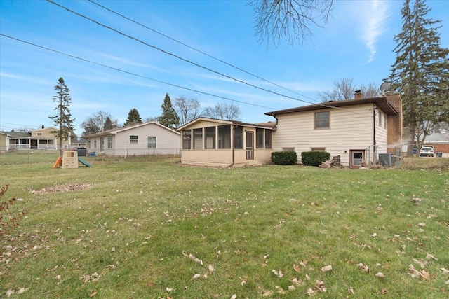 back of property with a sunroom, a playground, a yard, and central air condition unit