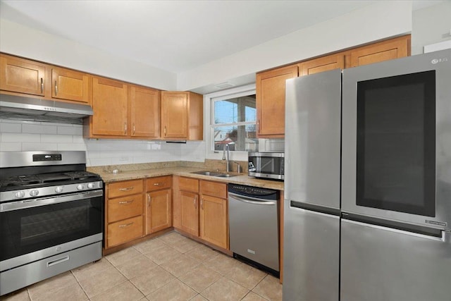 kitchen with backsplash, sink, light tile patterned floors, stainless steel appliances, and extractor fan