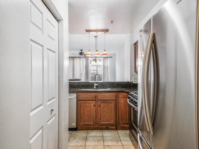 kitchen with stainless steel appliances, ceiling fan, sink, light tile patterned floors, and decorative light fixtures