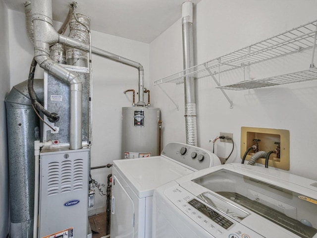 laundry room featuring gas water heater and separate washer and dryer