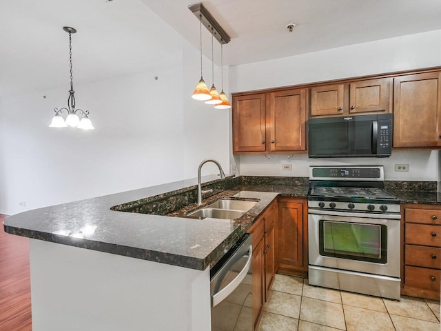 kitchen with kitchen peninsula, pendant lighting, stainless steel appliances, and sink