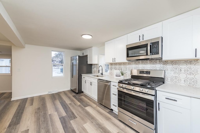 kitchen with sink, white cabinets, and stainless steel appliances