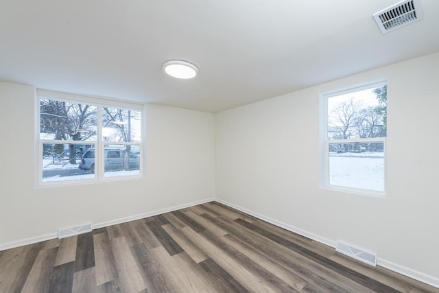 empty room with dark hardwood / wood-style flooring