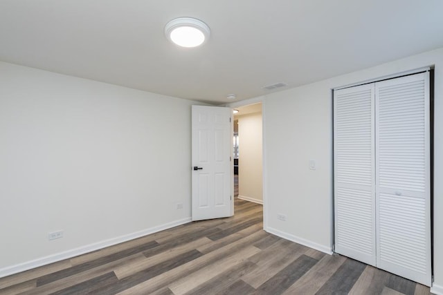 unfurnished bedroom featuring dark hardwood / wood-style floors and a closet