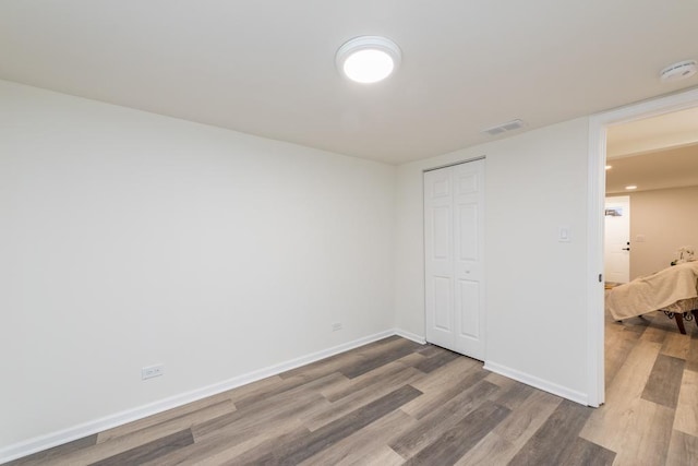 unfurnished bedroom with wood-type flooring and a closet