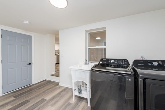 laundry room with washer and clothes dryer and hardwood / wood-style floors