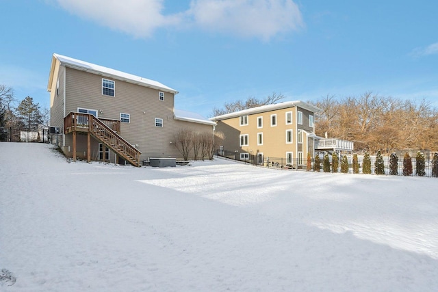 snow covered house featuring a wooden deck