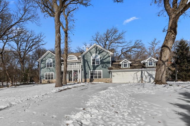 view of front of property featuring a garage, stone siding, and a chimney