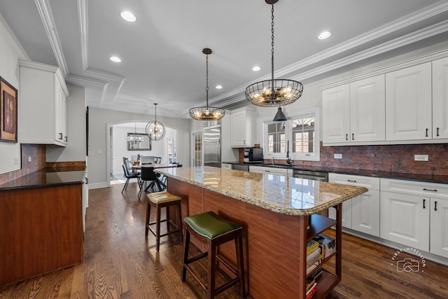 kitchen featuring appliances with stainless steel finishes, a center island, pendant lighting, and white cabinets