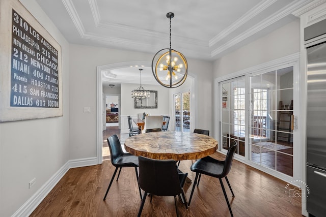 dining space with dark wood-style floors, a raised ceiling, a notable chandelier, and baseboards