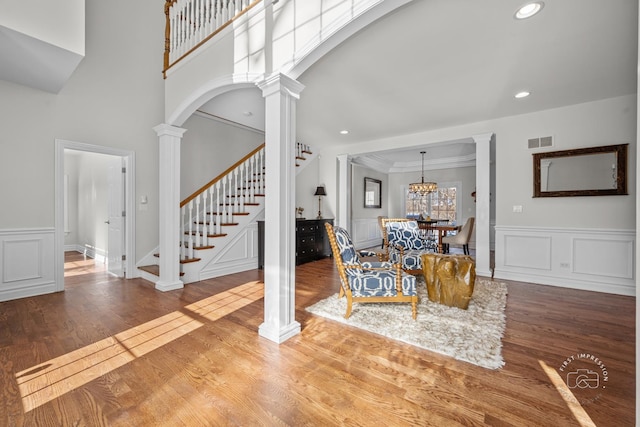 interior space with arched walkways, wood finished floors, stairs, and ornate columns