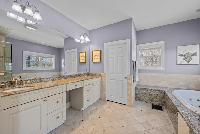 bathroom with visible vents, a sink, a jetted tub, and double vanity