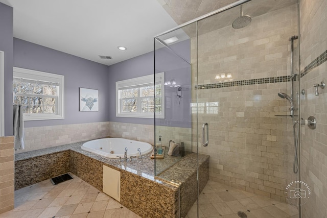 full bathroom featuring a jetted tub, a shower stall, and visible vents