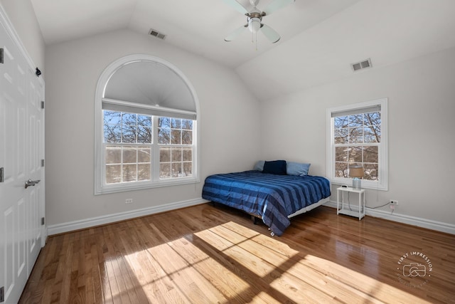 bedroom with lofted ceiling, multiple windows, and visible vents