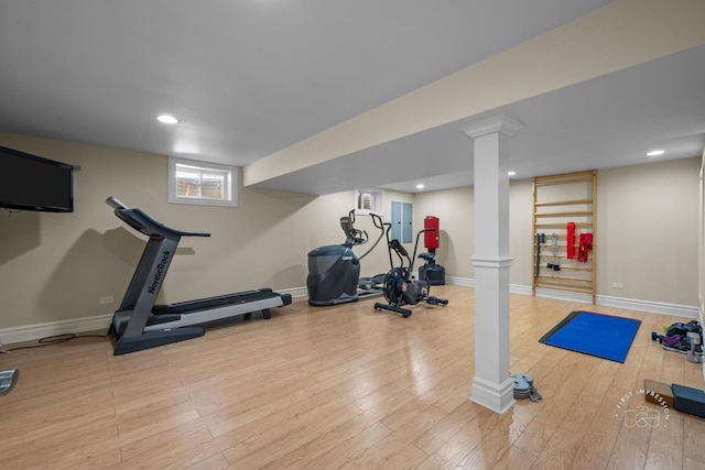 exercise area featuring light wood-style flooring, decorative columns, baseboards, and recessed lighting