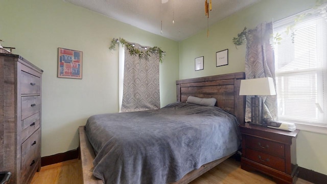 bedroom featuring multiple windows, ceiling fan, and light hardwood / wood-style floors