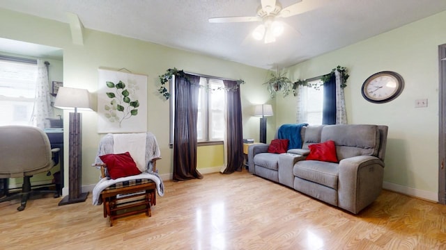 living area featuring ceiling fan, plenty of natural light, and light wood-type flooring