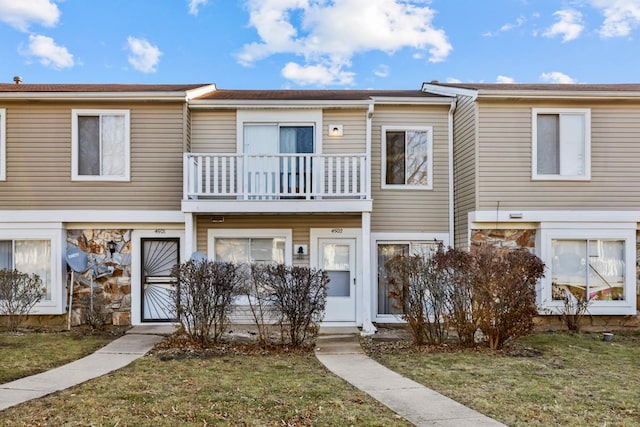 townhome / multi-family property featuring a front yard and a balcony