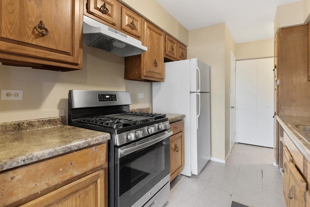 kitchen featuring white refrigerator and stainless steel gas range oven