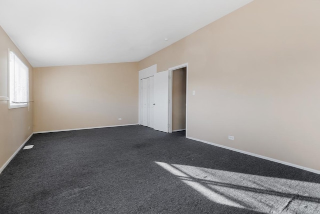 carpeted spare room with lofted ceiling