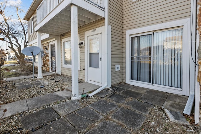 view of exterior entry with a balcony