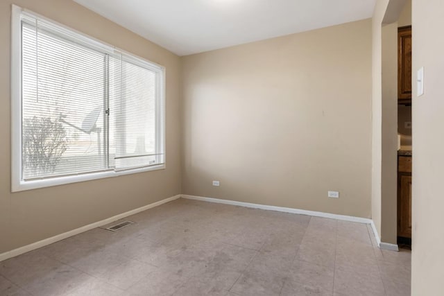 empty room featuring light tile patterned floors and plenty of natural light