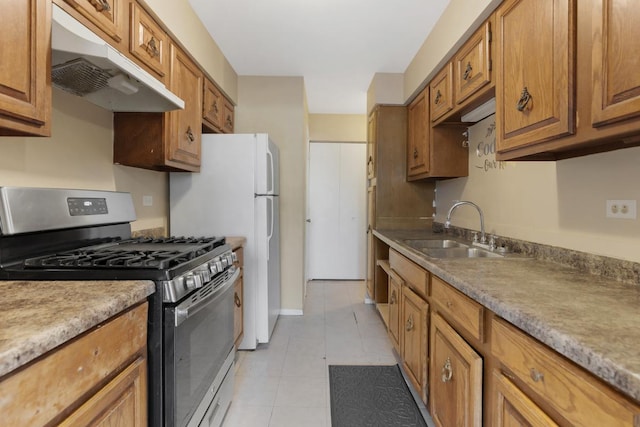 kitchen with light tile patterned floors, sink, and stainless steel range with gas stovetop