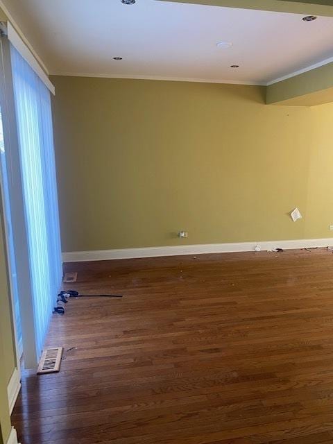 empty room with ornamental molding and dark hardwood / wood-style floors