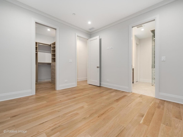 1208 W Wellington St Unit 1F, Chicago, IL 60657 - unfurnished bedroom with crown molding, recessed lighting, light wood-style flooring, and a spacious closet