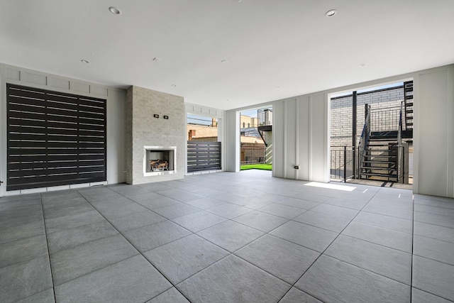 unfurnished living room with a fireplace and tile patterned floors