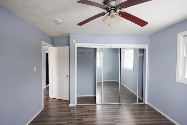 unfurnished bedroom featuring ceiling fan, dark hardwood / wood-style floors, and a closet