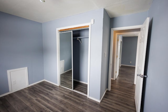 unfurnished bedroom featuring dark hardwood / wood-style flooring and a closet